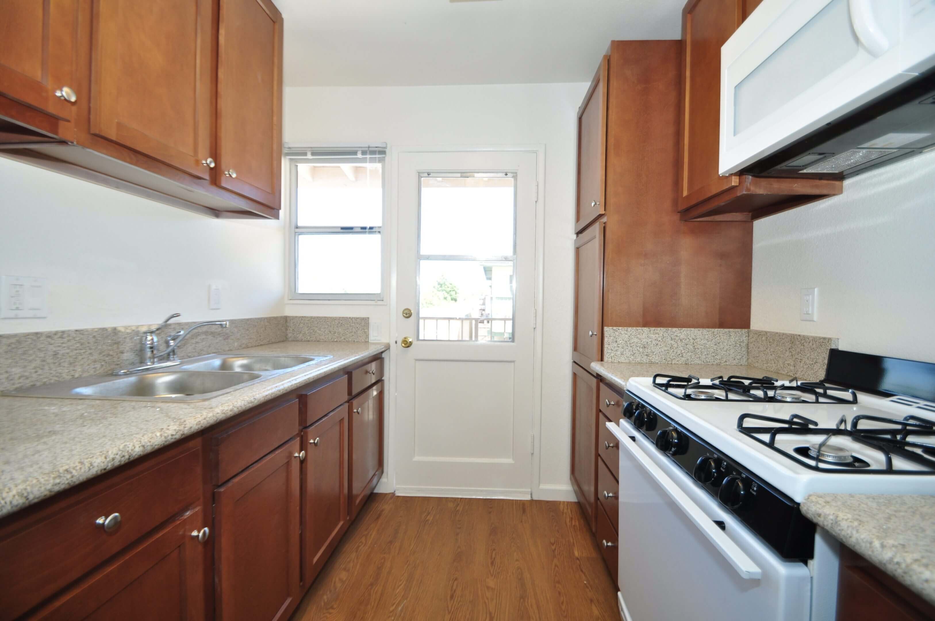 Galley kitchen with wooden cabinets and stove